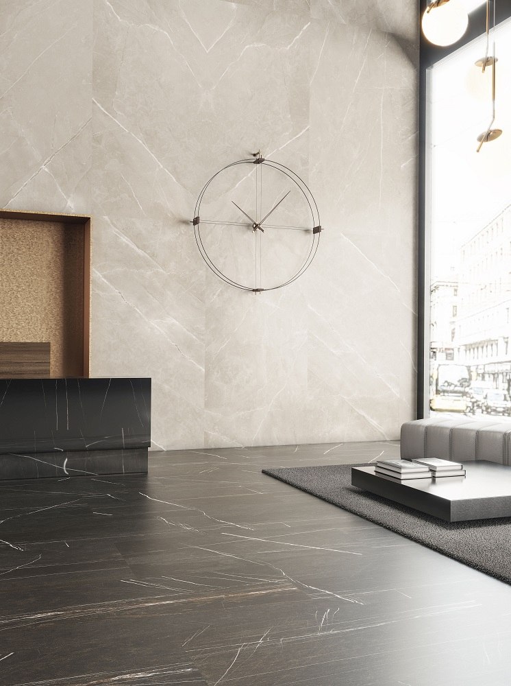 Delmori Clock Wanduhr: Moderne Design Wanduhr in Schwarz und Walnuss an einer Marmorwand.