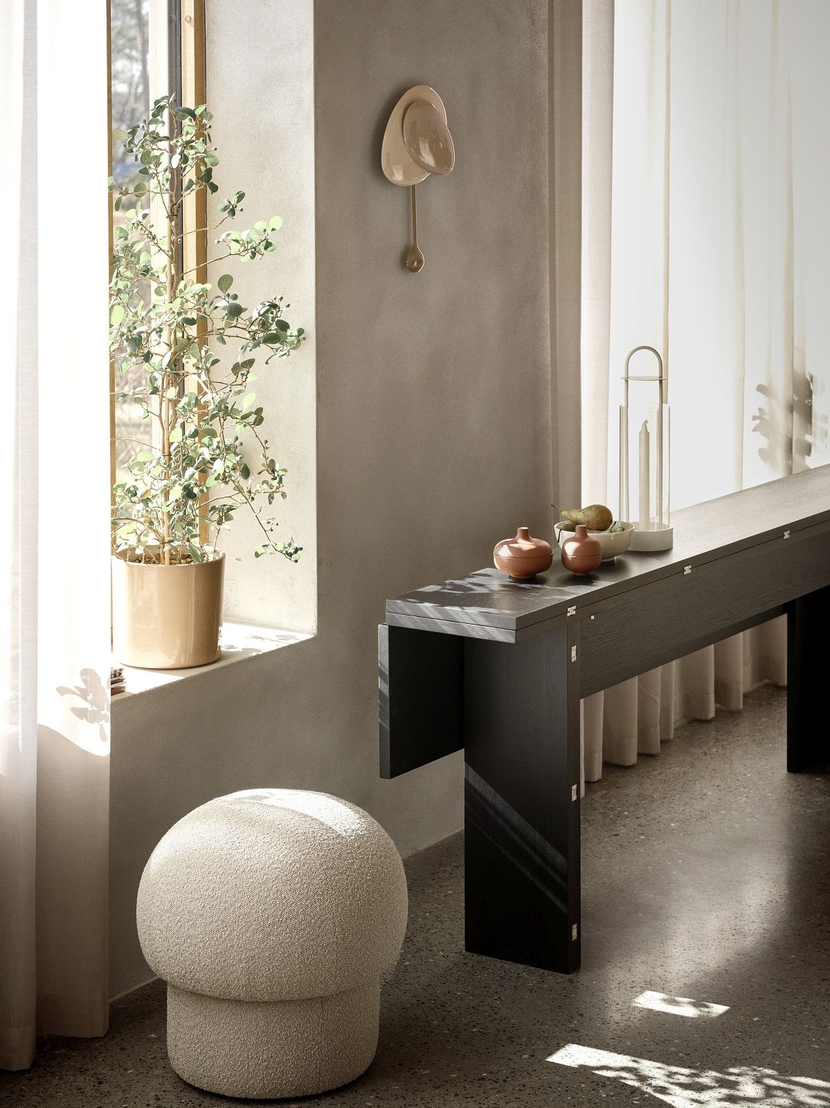 Beiger Uno Pouf Hocker von Design House Stockholm im stilvollen Interieur mit Tisch und Dekoration.