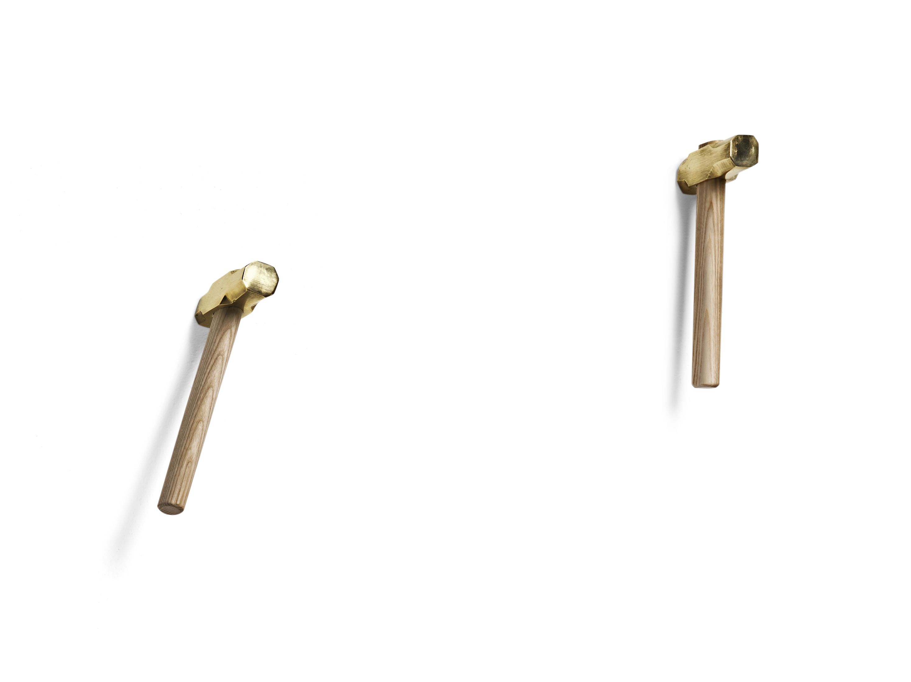 Zwei Bastaaa Kleiderhaken aus Holz und Messing an einer weißen Wand. Moderne Wandhaken.