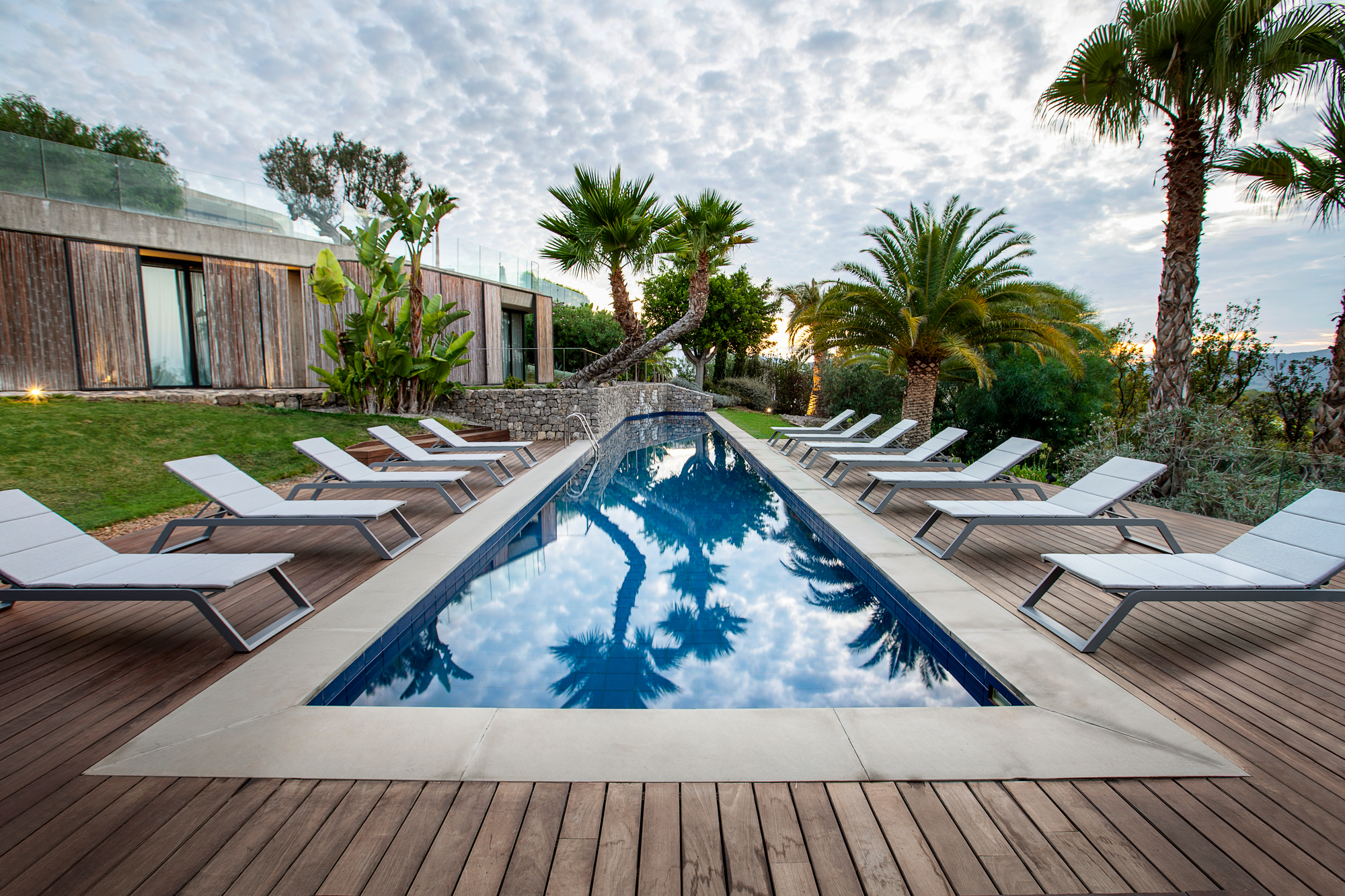 Sonnenliegen am Pool mit Cane-Line Outdoor Kissen für entspannte Stunden im Freien.