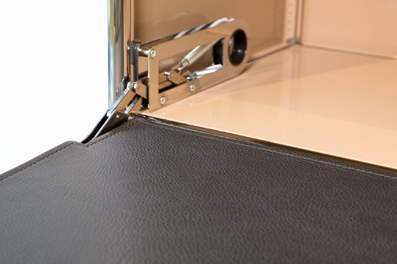 Detailaufnahme einer braunen Lederauflage für einen USM Schreibtisch mit Befestigungselementen.