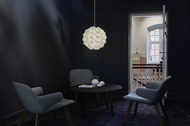 Le Klint Pendelleuchte Model 172 Medium über Tisch mit Stühlen im dunklen Raum.