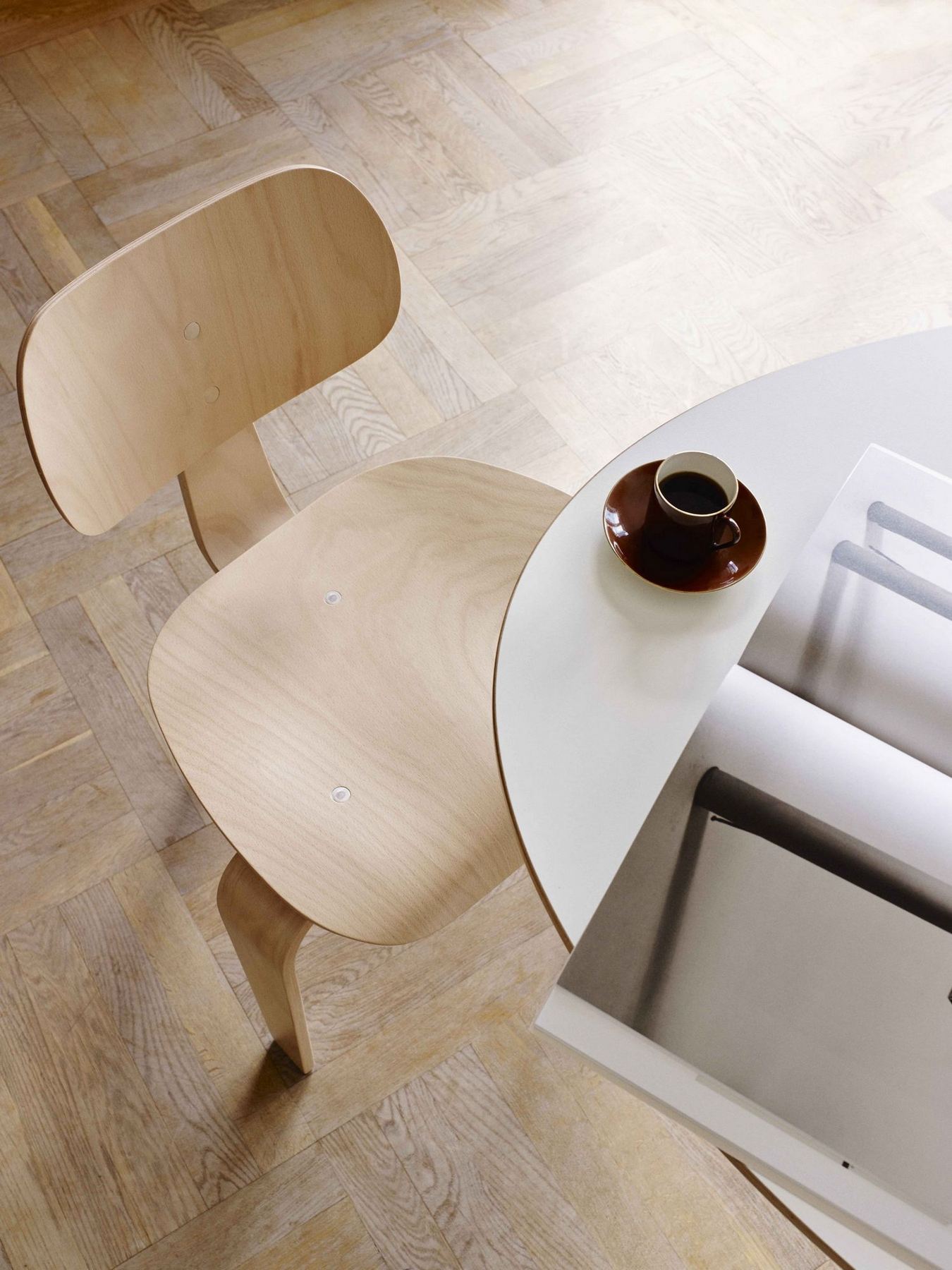 Draufsicht: Heller SE 42 Stuhl von Wilde+Spieth neben Tisch mit Kaffeetasse. Designmöbel.