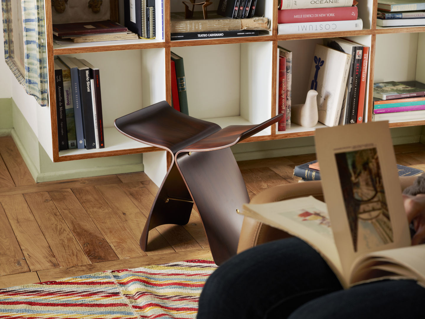 Vitra Butterfly Stool Hocker aus Palisanderholz im Wohnzimmer, Designklassiker und Sitzmöbel.