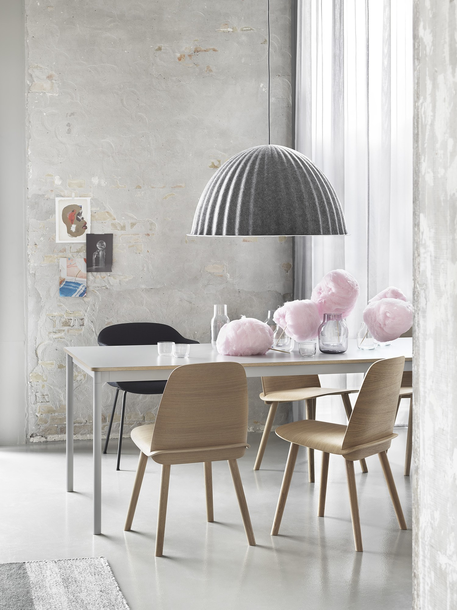 Graue Under The Bell Pendelleuchte von Muuto über Esstisch mit Stühlen in modernem Esszimmer.