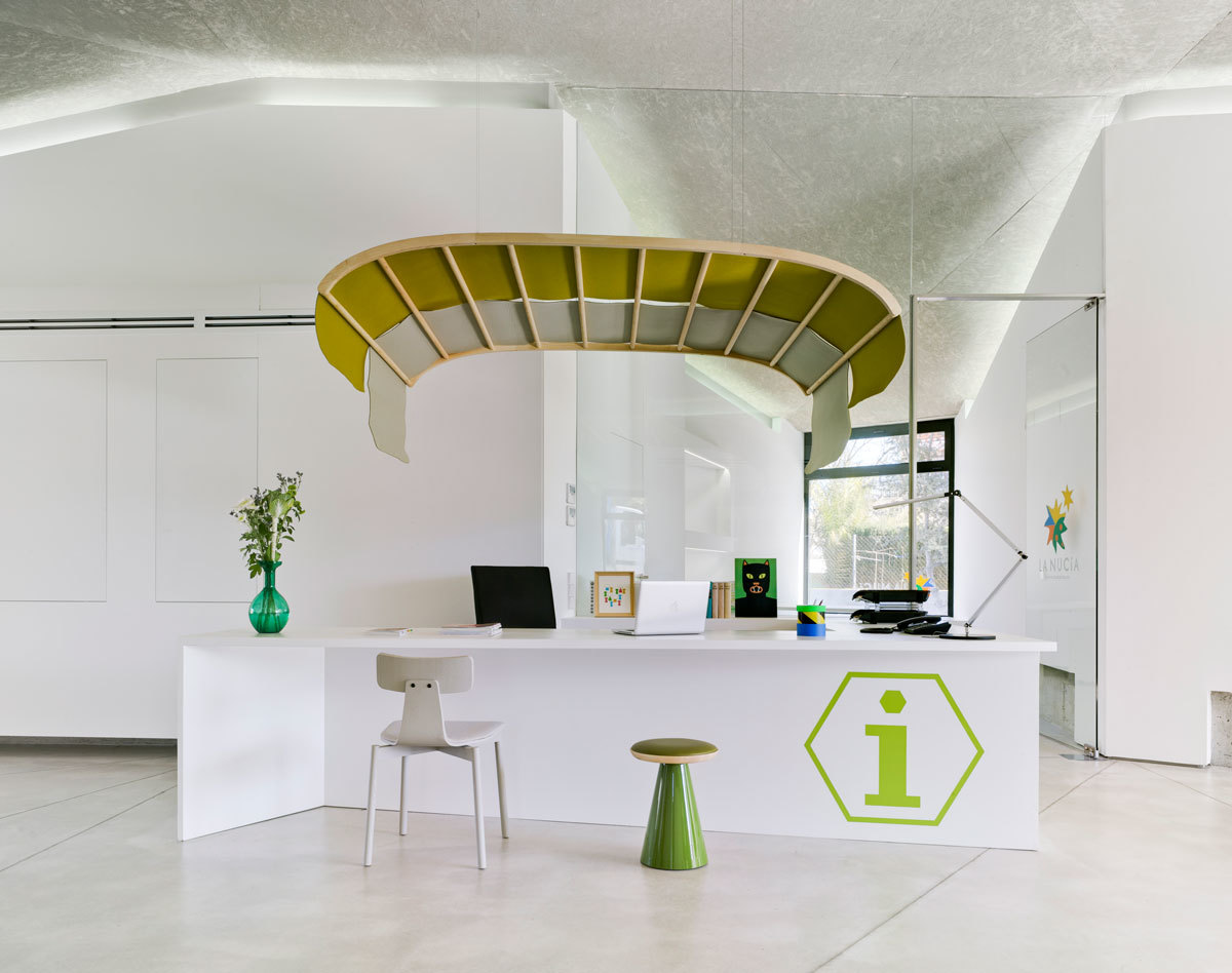 Pion Hocker Limone von Sancal vor einem Empfangstresen mit Infobereich. Grüner Design-Hocker.