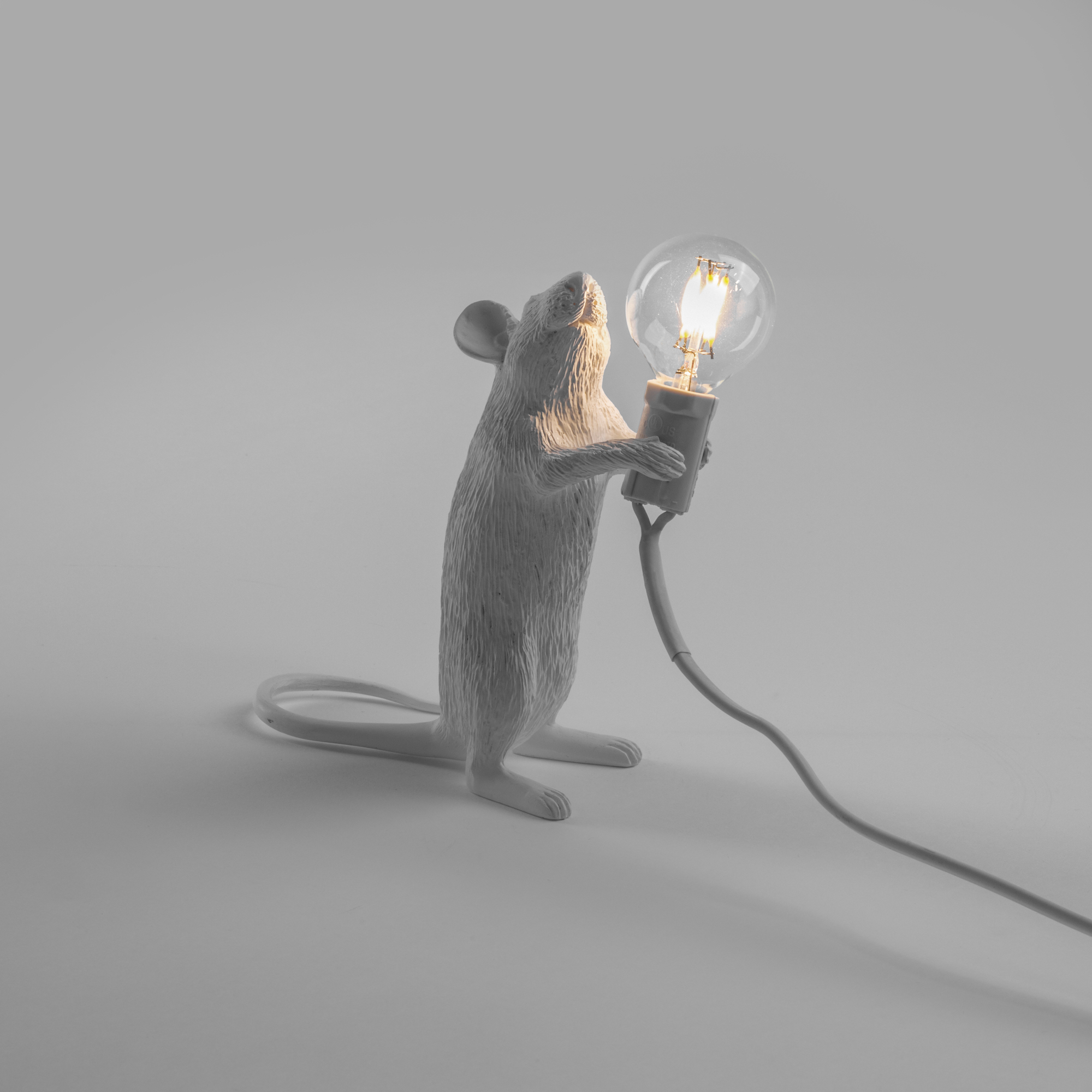 Stehende Mouse Lamp Tischleuchte von Seletti: Weiße Maus hält eine leuchtende Glühbirne.