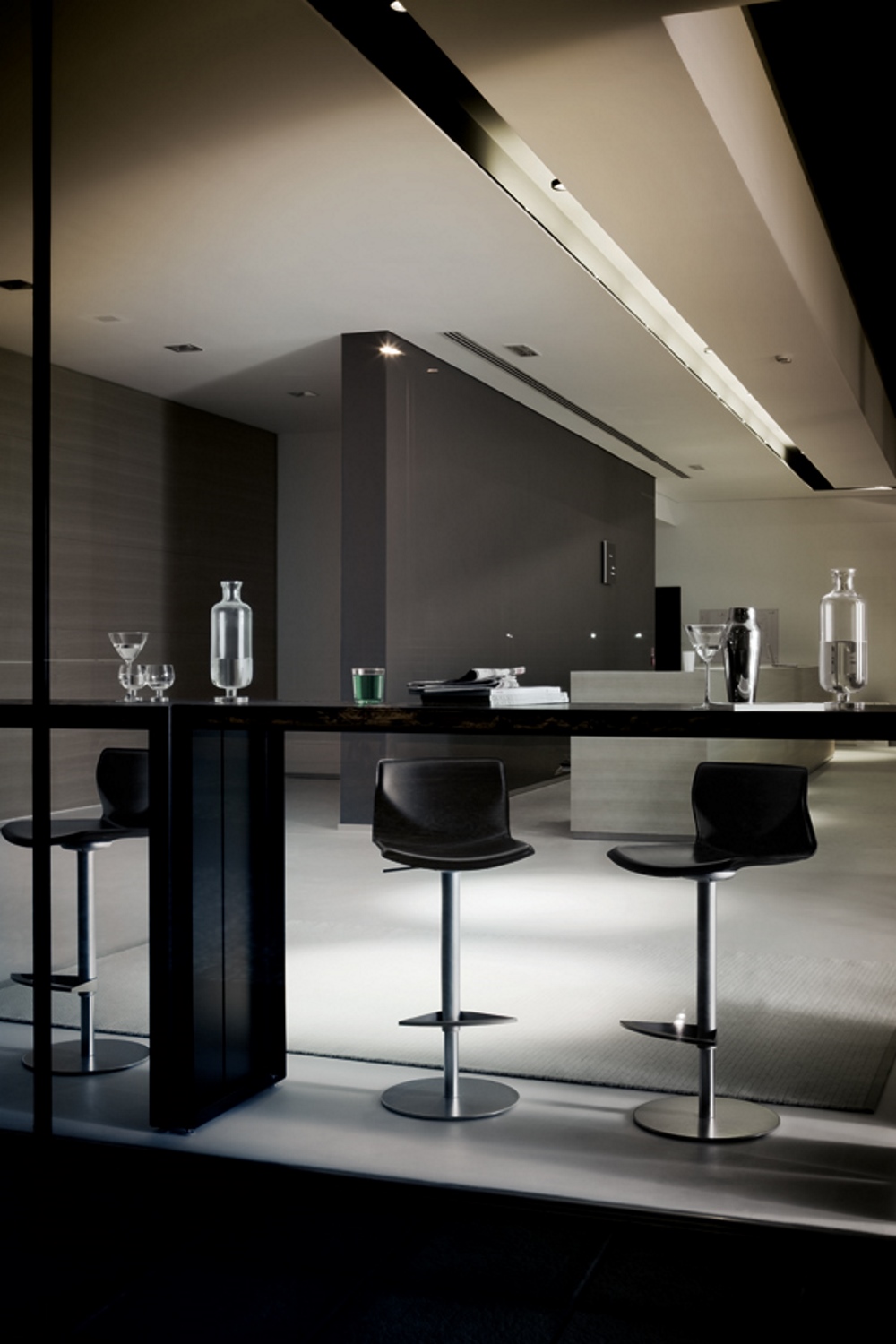 Moderner, dunkler Tresentisch mit Barhockern, Gläsern und Karaffen. Panco Tresentisch für stilvolle Bar- und Loungebereiche.