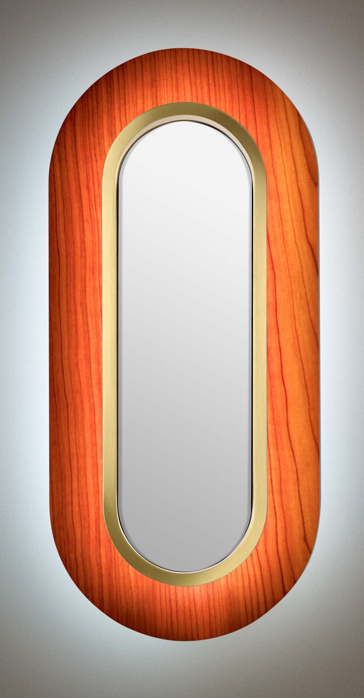 Lens LED Wandleuchte von LZF Lamps: Ovale Lampe mit Kirschholz und goldenem Metallring.