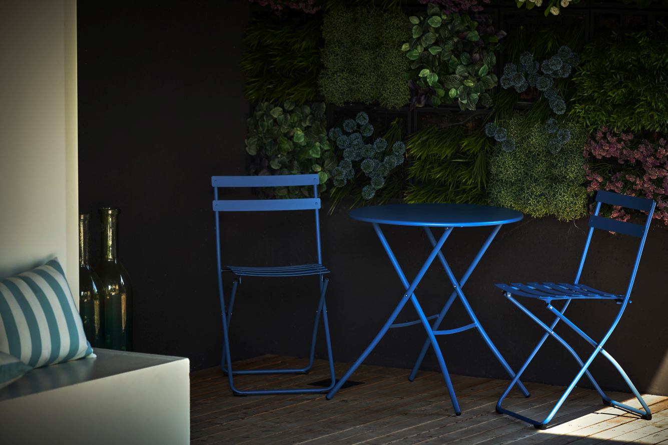 Blauer Fiam Klapptisch Ø 67 cm von Jan Kurtz mit zwei passenden Stühlen im Garten.