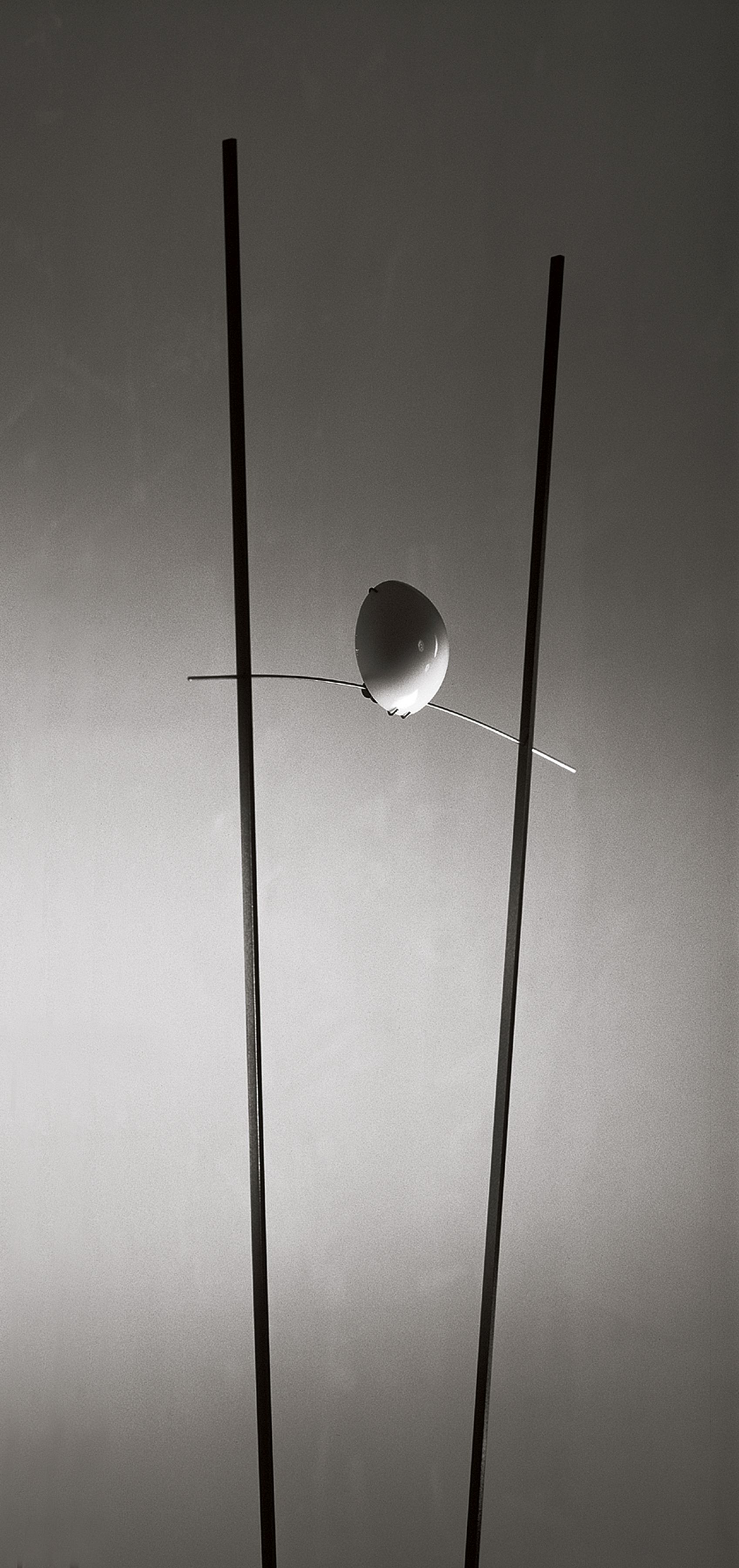 Ilios Stehleuchte von Ingo Maurer, silberfarben, mit zwei vertikalen Stäben und einer Kugel.