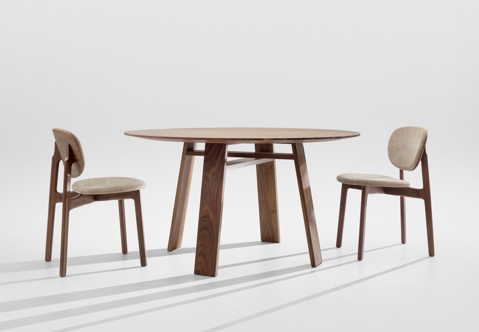 BONDT Tisch: Runder Holztisch mit zwei passenden Stühlen auf weißem Hintergrund. Esszimmermöbel.