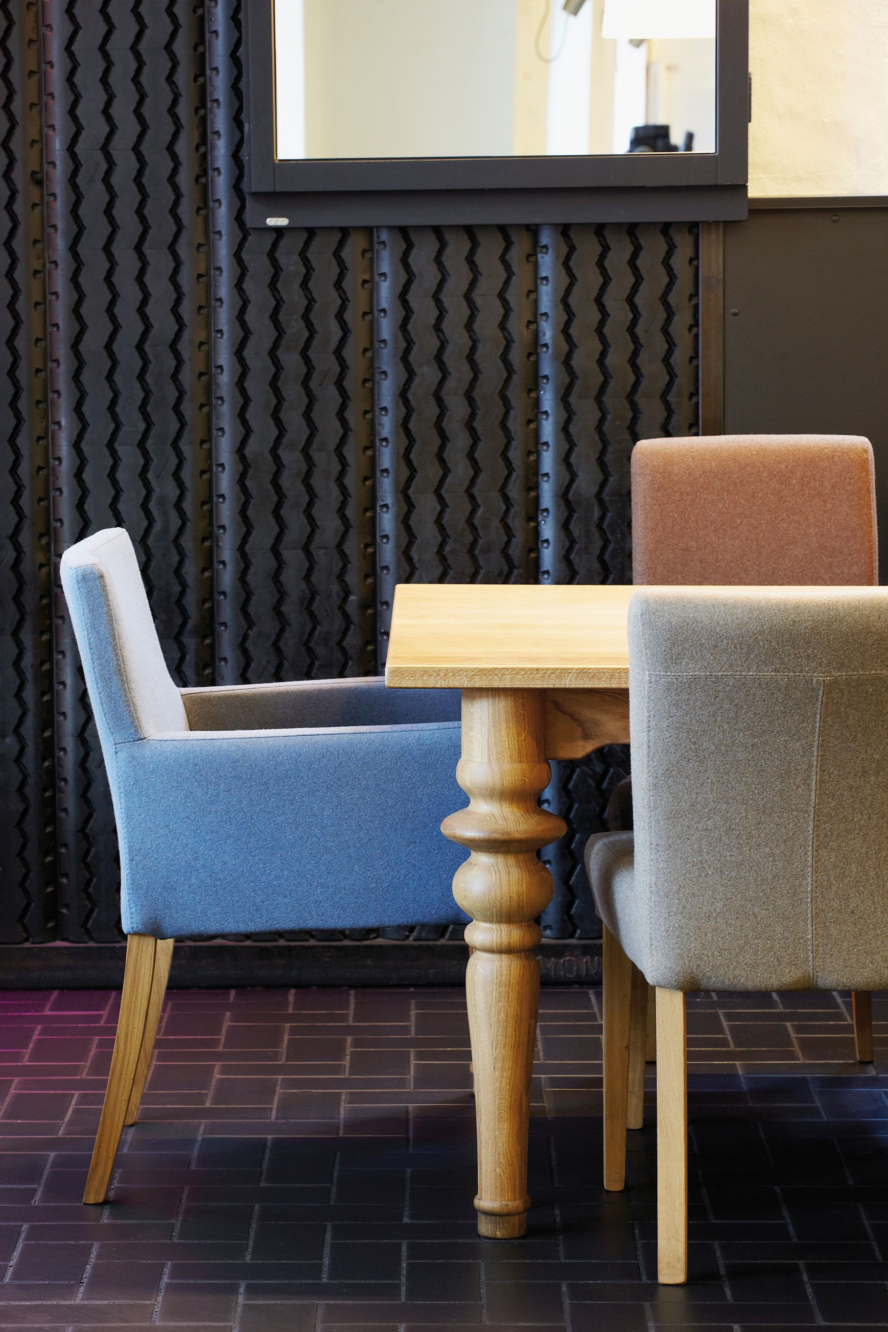 Drexler Tisch von Jan Kurtz aus Holz mit Stühlen in verschiedenen Farben.