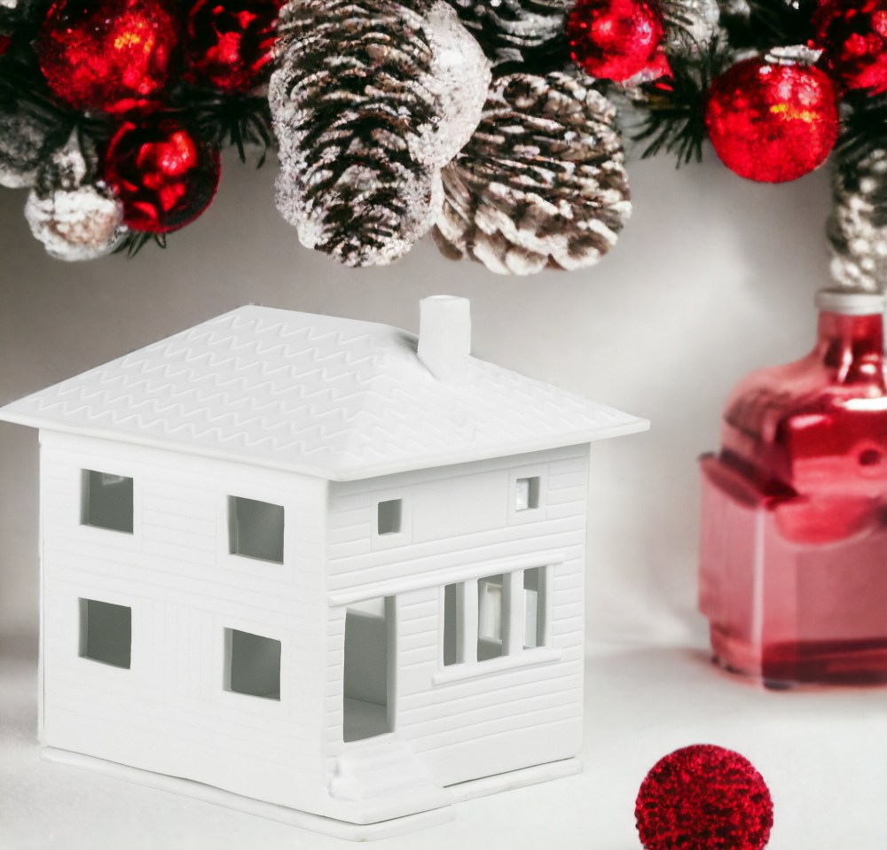 Weißes Lichthaus im Stadtvilla-Stil von Räder, festliche Weihnachtsdekoration mit roten Kugeln und Tannenzapfen.