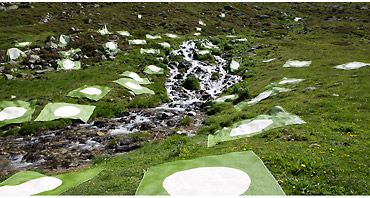 Pappelina Vera One Teppich 180x230 cm im Grünen: Outdoor-Kunstinstallation mit robusten, hellgrünen Kunststoffteppichen am Bach.