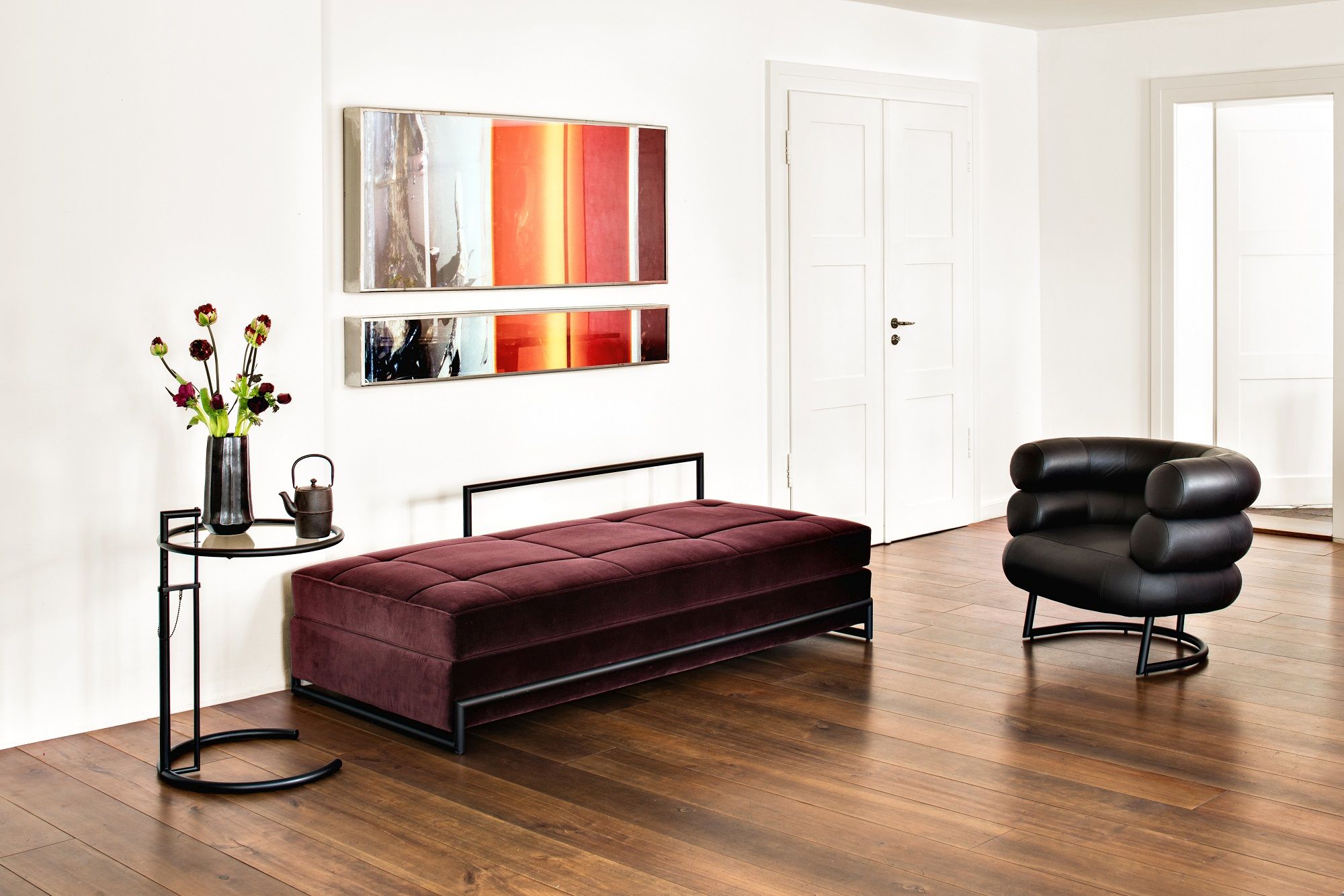 Burgundfarbenes Day Bed Classicon Liege mit schwarzem Gestell in modernem Wohnzimmer.