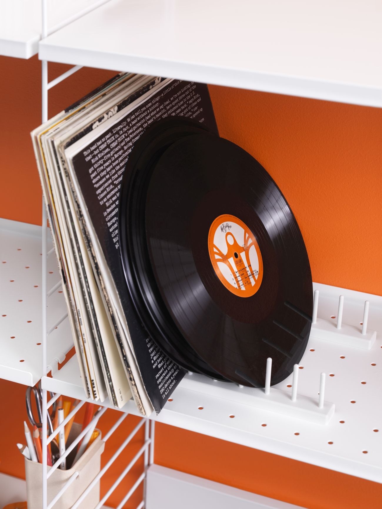 Weißes String Regalsystem mit Schallplatten und Büroartikeln. Wandregal für Wohnzimmer und Büro.