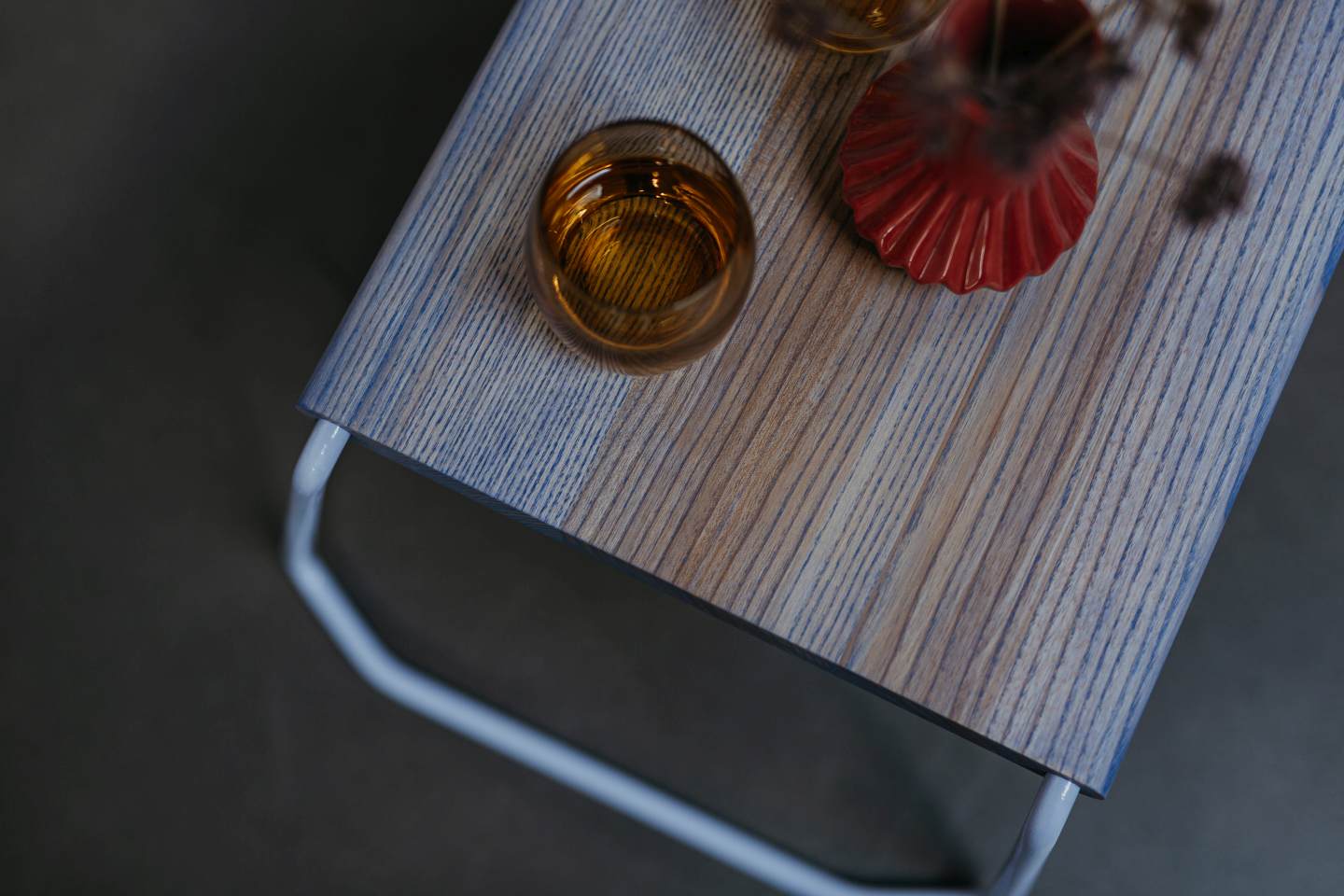 Nahaufnahme des D:002 Beistelltisches von Fuchs & Habicht in Weiß mit Getränk und Dekoration.