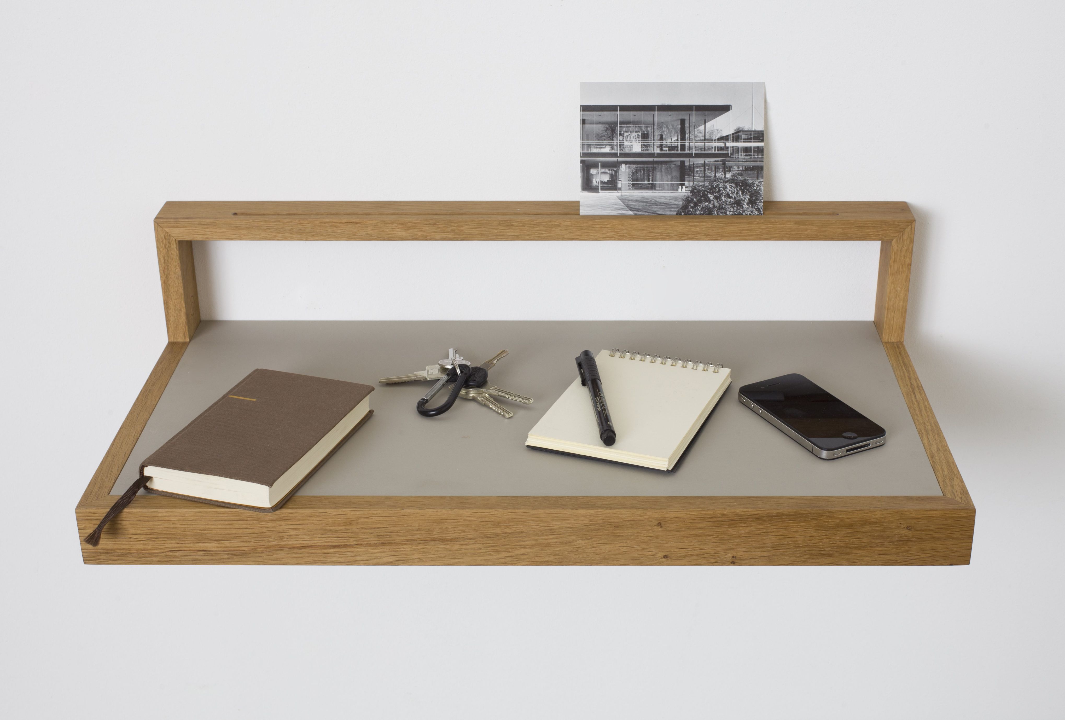 Hellgraues Ablageboard "buck1" mit Notizbuch, Stift, Handy und Schlüssel. Wandregal aus Holz für Büro und Zuhause.