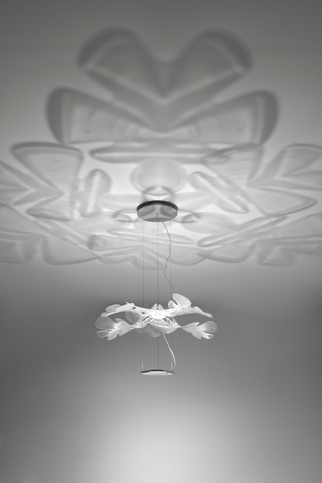 Chlorophilia Pendelleuchte von Artemide: Moderne Hängelampe mit Chromstruktur und transparenten Diffusoren, die ein einzigartiges Lichtspiel erzeugt.