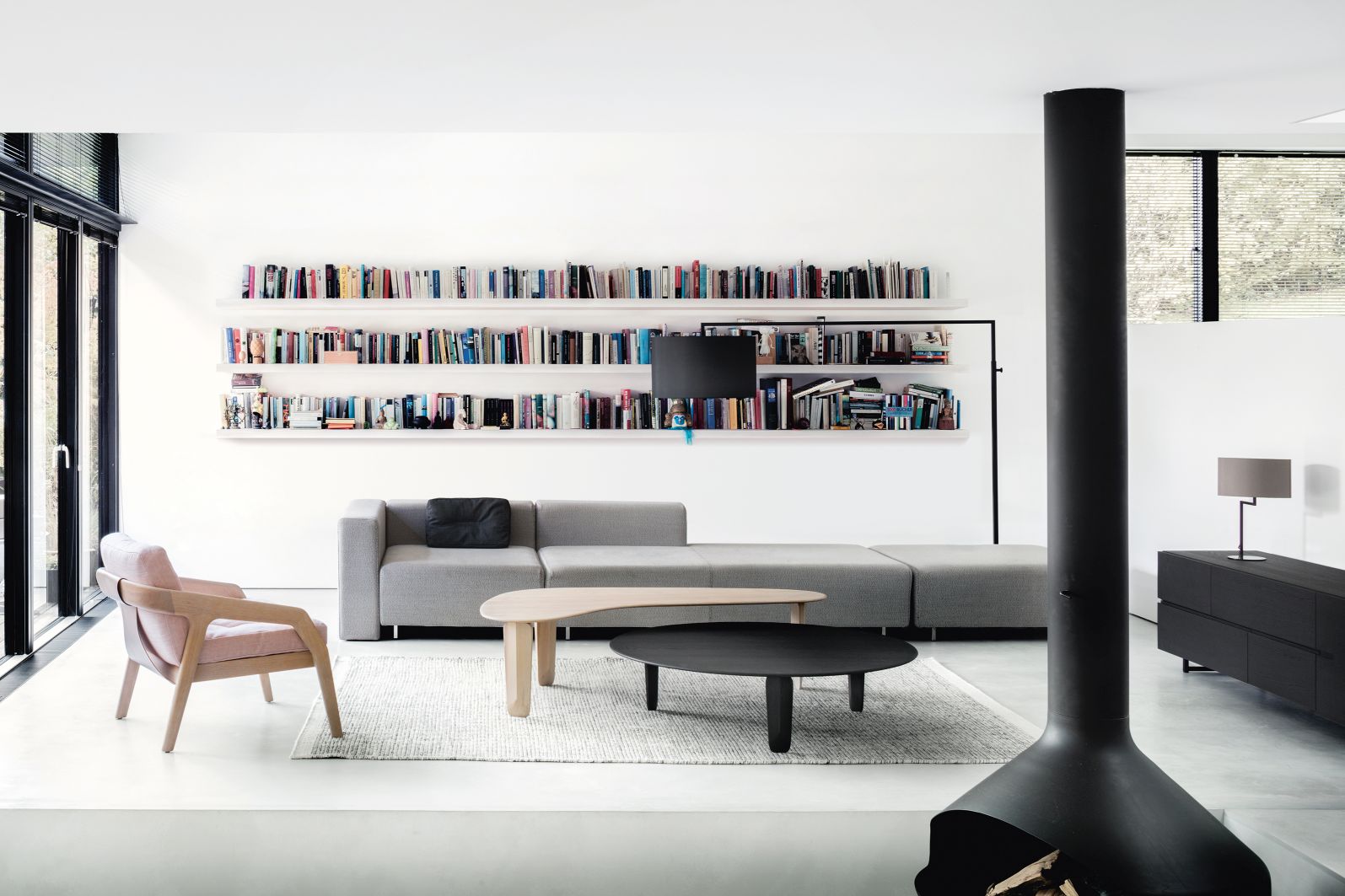 High Noon Stehleuchte in Weiß im modernen Wohnzimmer mit Bücherregal und Kamin.