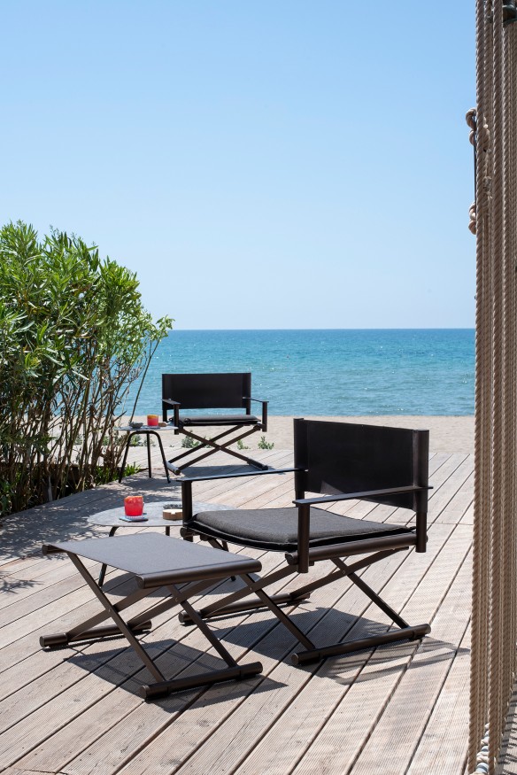 Emu Terra Lounge Chair Outdoor Sessel auf Holzterrasse mit Meerblick, stilvolle Gartenmöbel und Beistelltisch.
