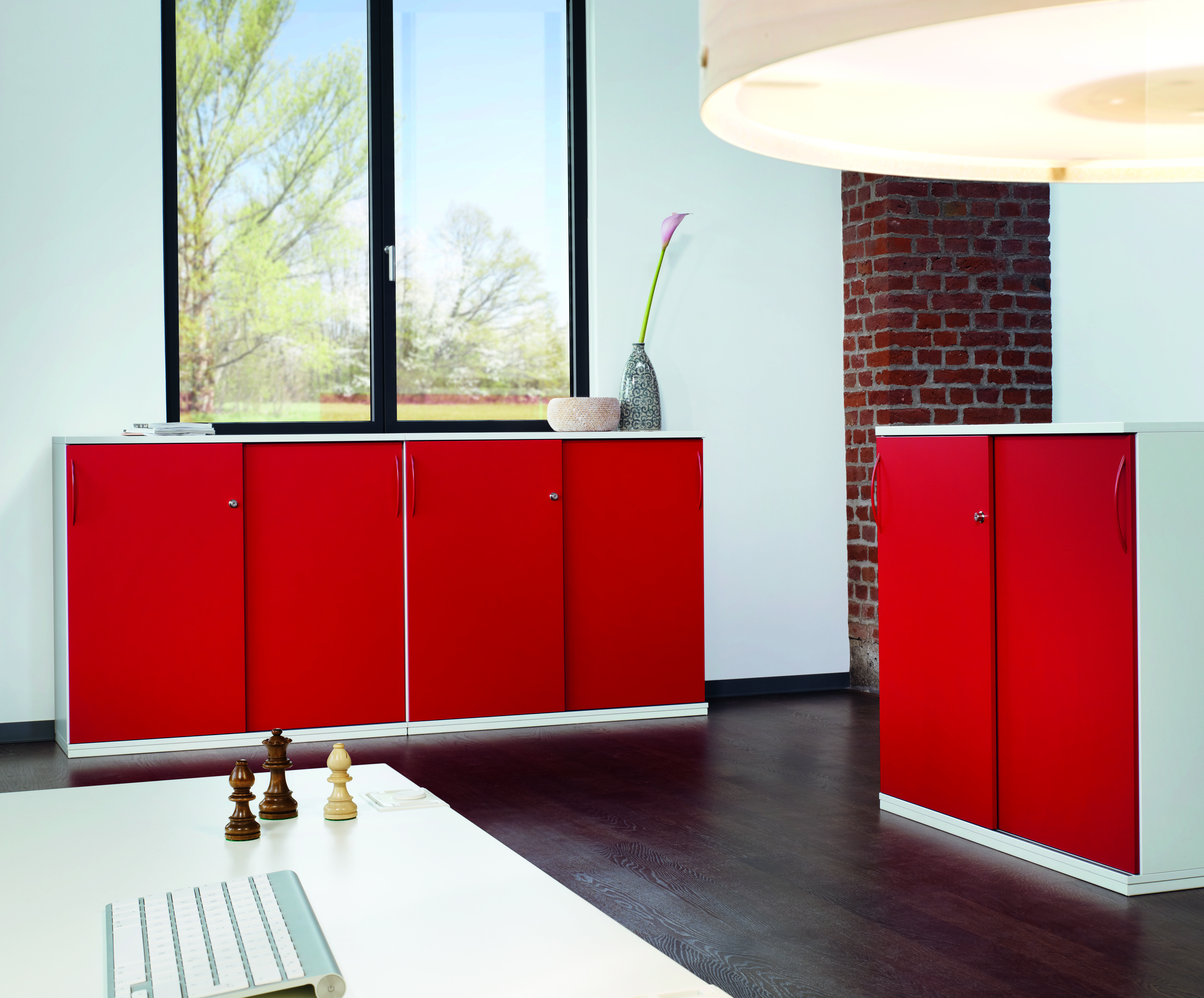Roter Acta Garderobenschrank von König+Neurath im modernen Büro, Schiebetüren und Stauraum für Bürobedarf.