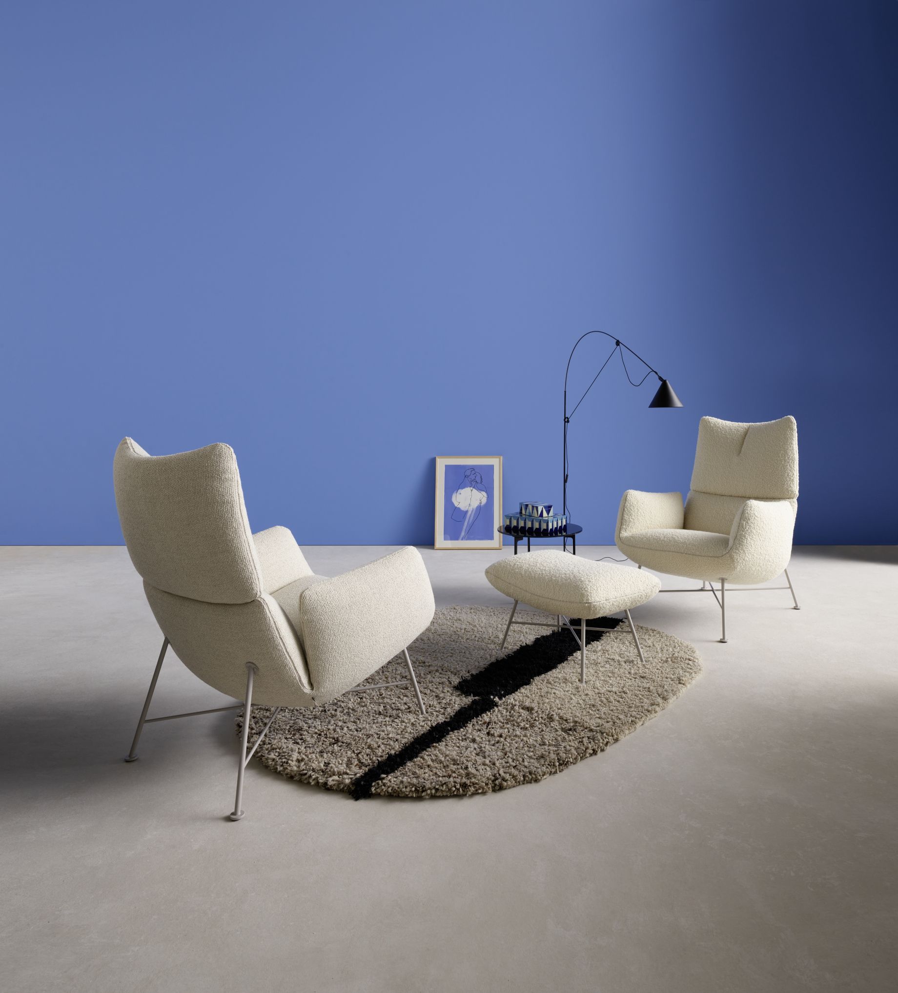 Jalis Lounge Sessel von Cor mit Drahtgestell, cremefarbenem Bezug und passendem Hocker auf Teppich.