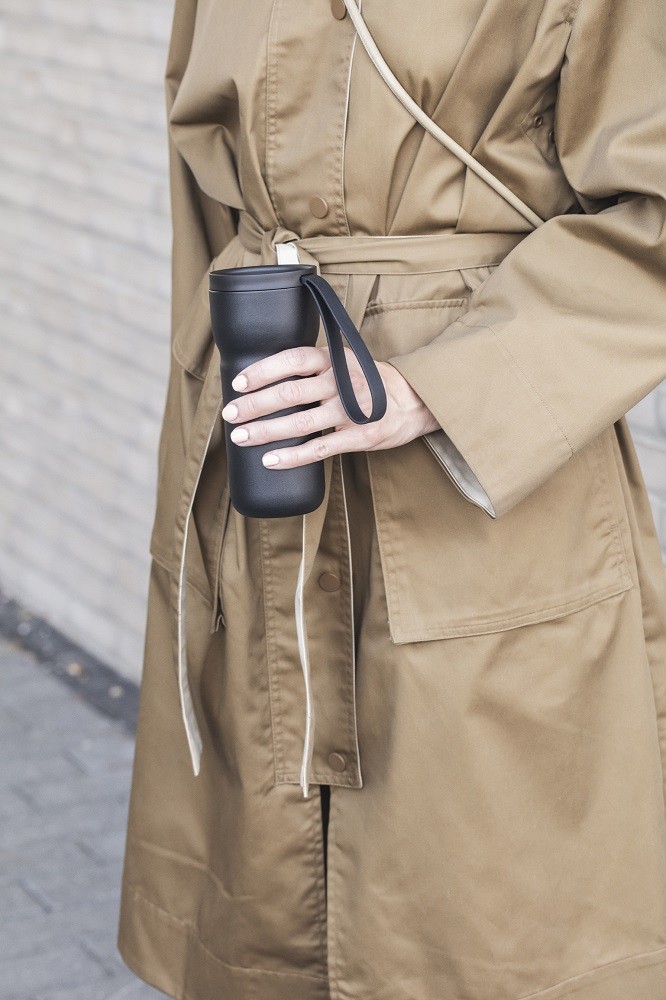 Frau hält schwarzen Eva Solo Thermobecher. Ideal für Kaffee, Tee und andere Getränke.