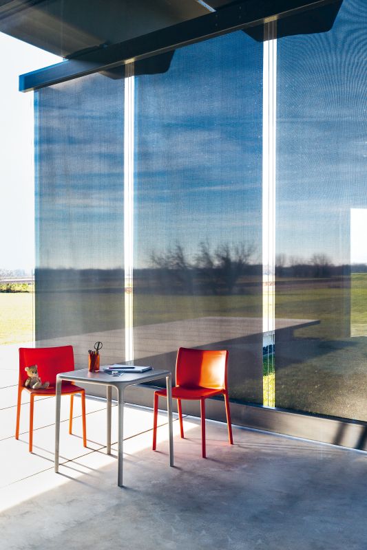 Air Table Magis: Quadratischer Tisch mit zwei roten Stühlen in modernem Ambiente.