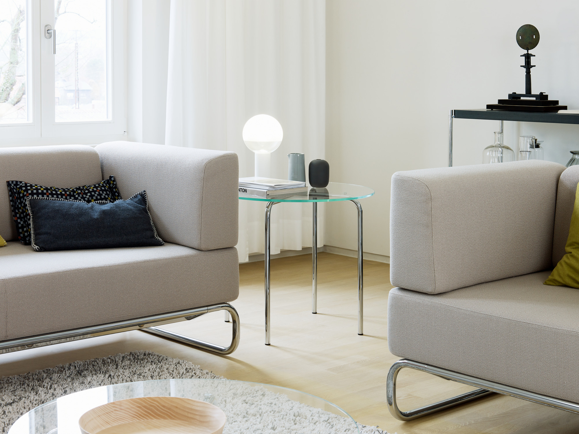 Heller Wohnraum mit zwei S 5001 Thonet Sesseln und Glasbeistelltisch, modernes Möbeldesign.