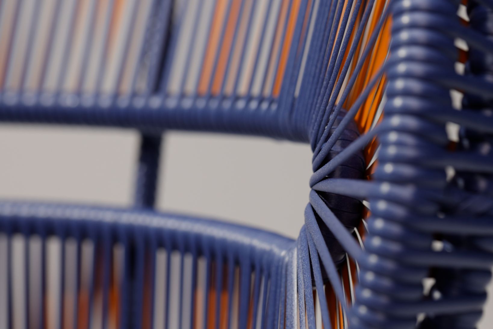 Detailaufnahme des Dedon Cirql Beistelltisches: Blaue und orangefarbene Outdoor-Möbel, modernes Design.