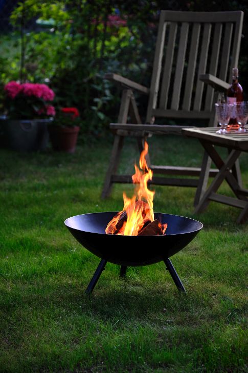 Flames Feuerschale L von Philippi mit brennendem Holz im Garten auf Rasen.