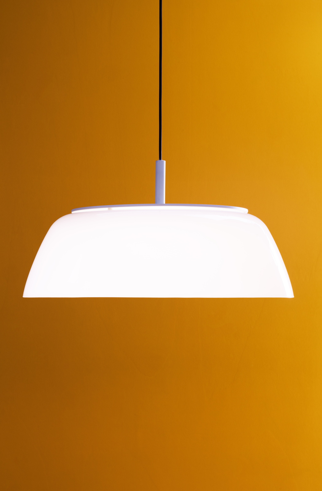 Weiße Onda Pendelleuchte von Martinelli Luce vor orangefarbenem Hintergrund, moderne Innenbeleuchtung.