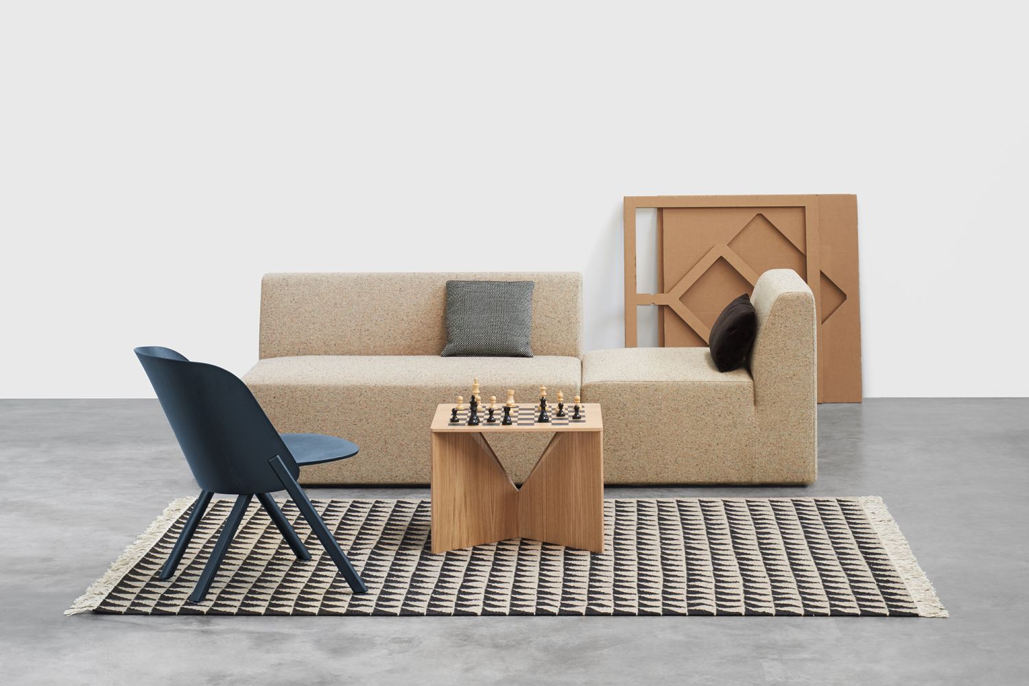 FK04 Calvert Couchtisch Eiche von e15 mit Schachbrettmuster auf modernem Sofa und Teppich.