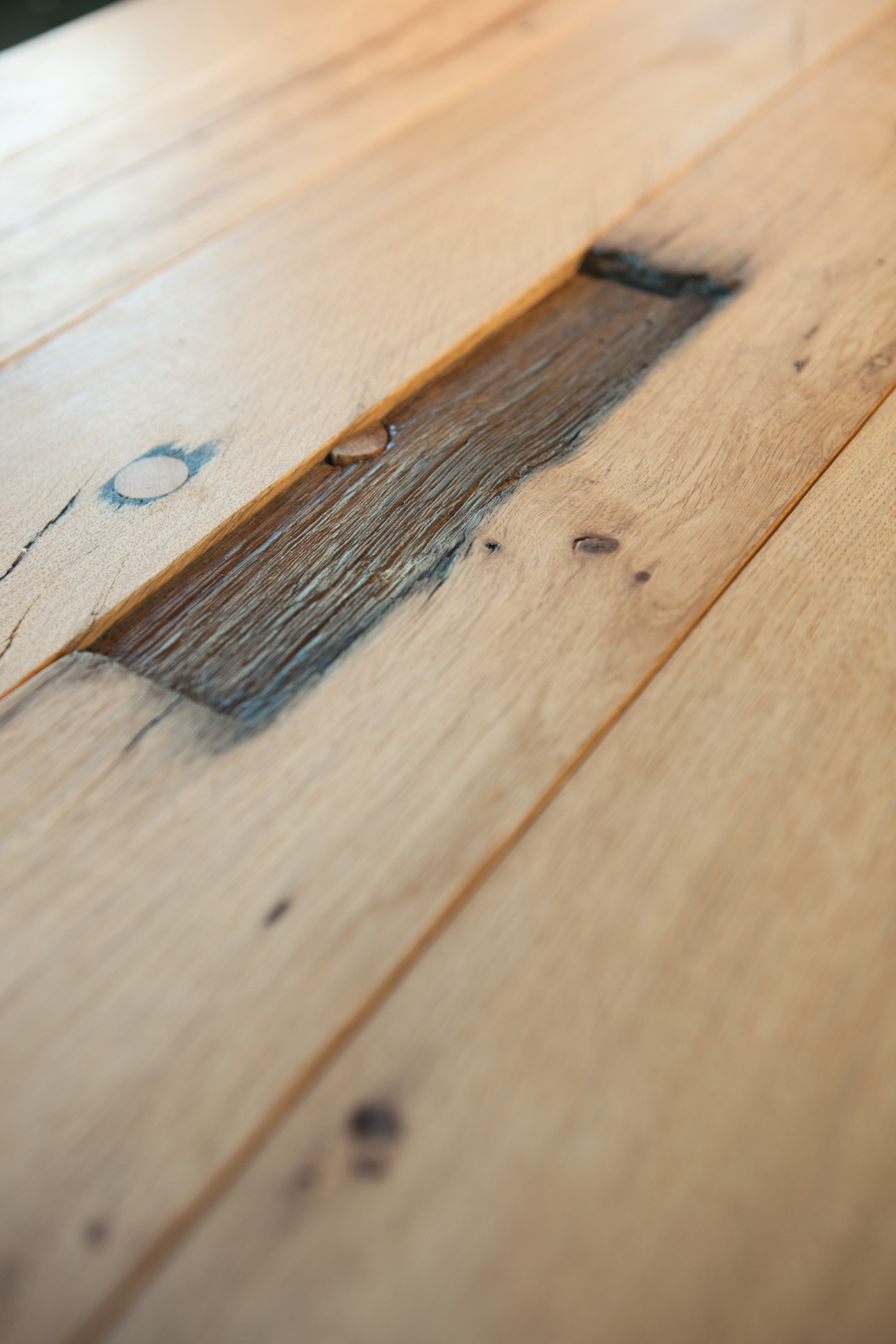 Detailaufnahme der geölten Eichenholz-Tischplatte BB 11 Clamp von Janua mit Astloch und Maserung.