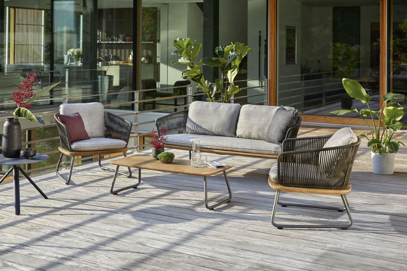 Denia Dining Sessel Outdoor mit Zori Matcha Polsterung von Weishäupl auf Holzterrasse.