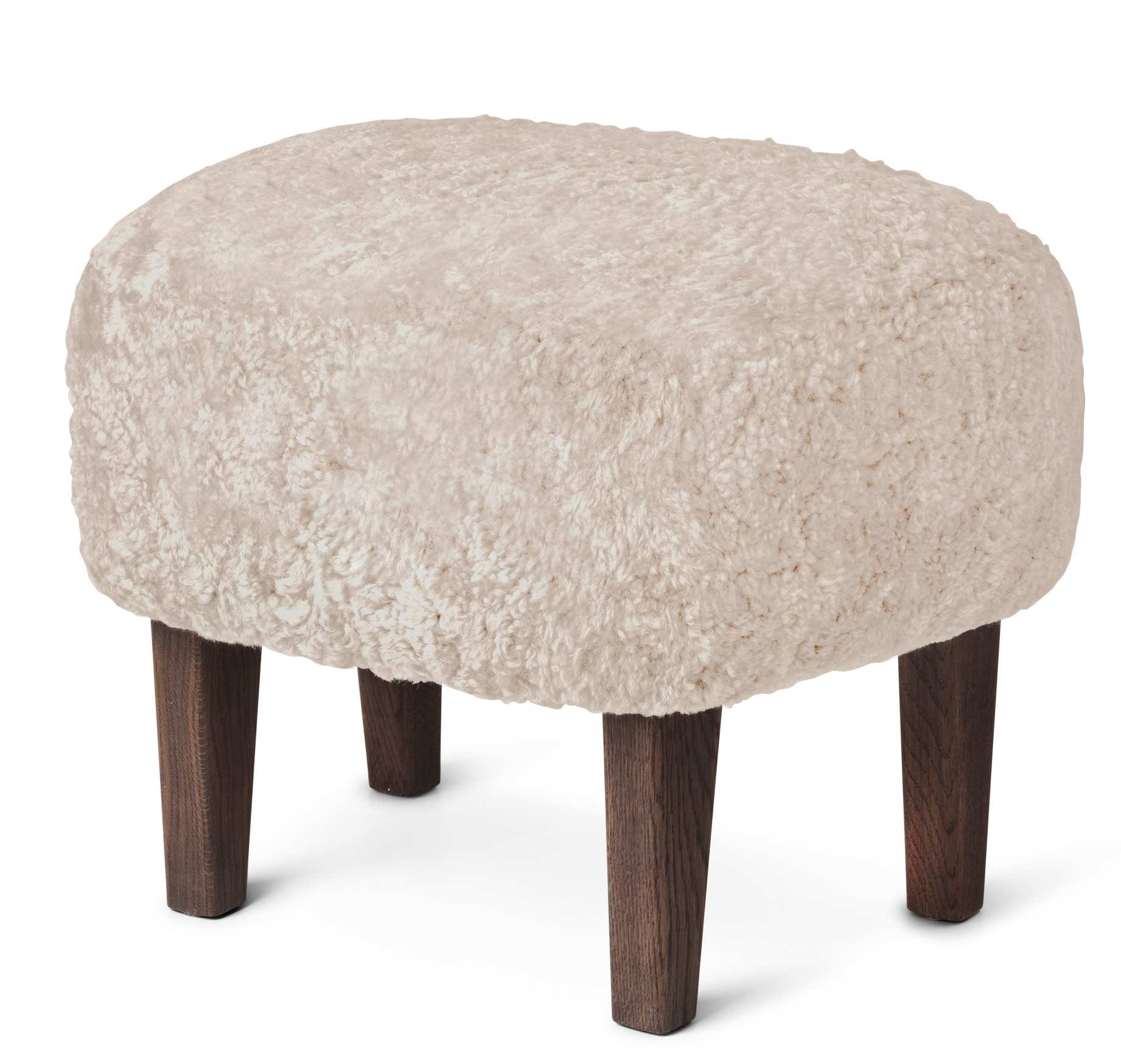 Ingeborg Ottoman von Audo: Gepolsterter Hocker mit cremefarbenem Schaffellbezug und dunklen Holzbeinen.