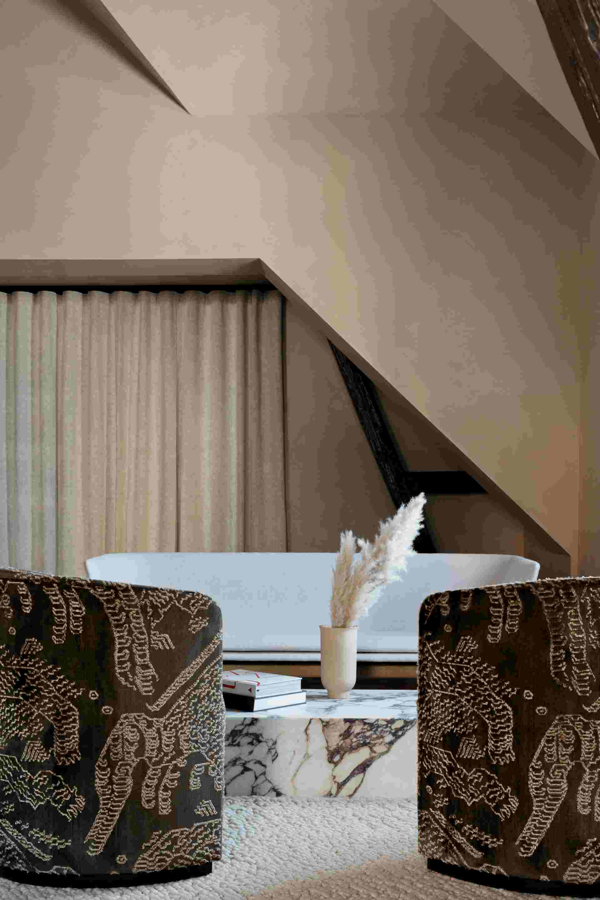 Nahaufnahme des Audo Plinth Low Beistelltisches aus schwarzem Marquina-Marmor in einem stilvollen Wohnzimmer.