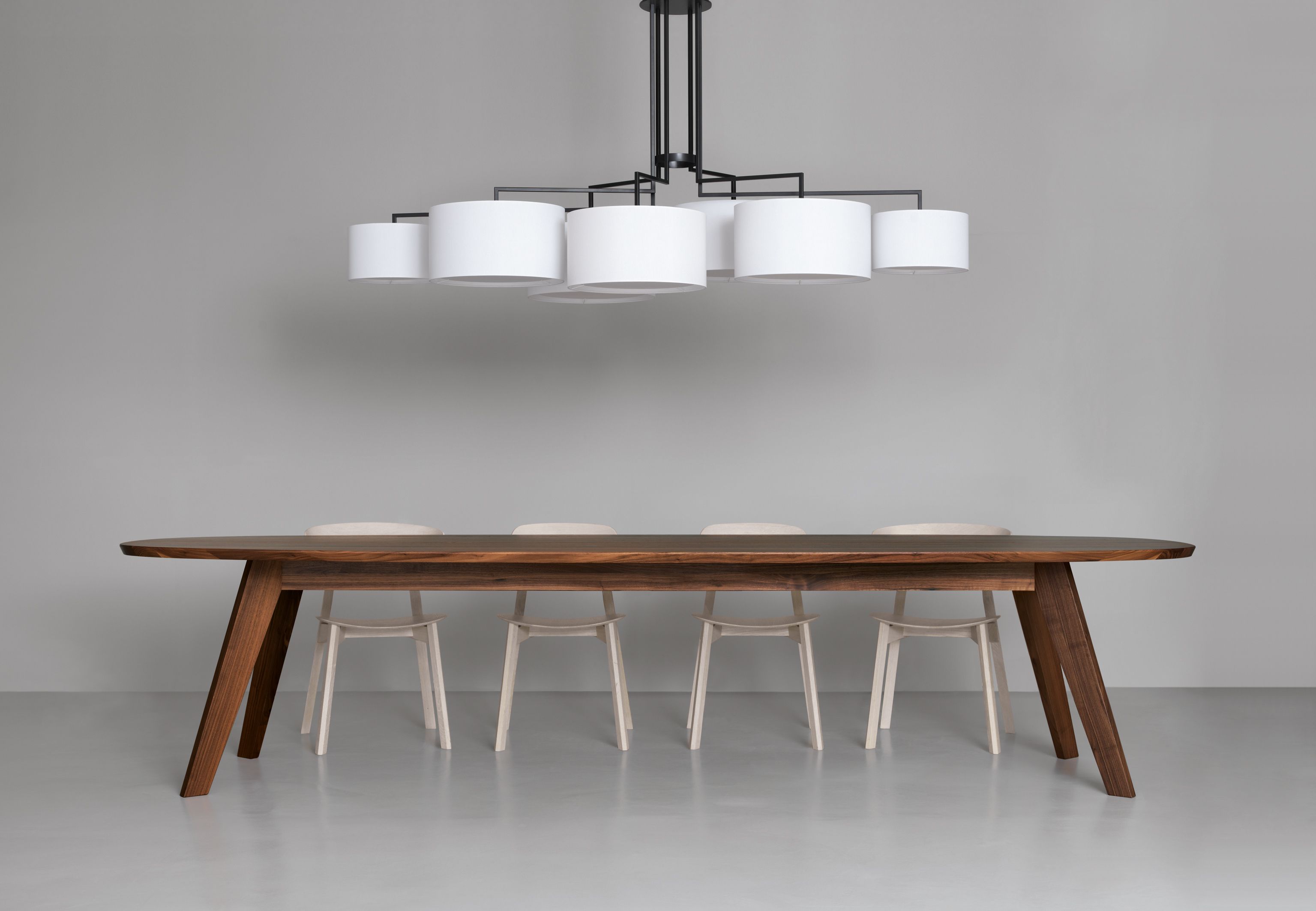 Ovaler CENA Esstisch aus dunklem Holz mit Stühlen und moderner Lampe für Esszimmer.