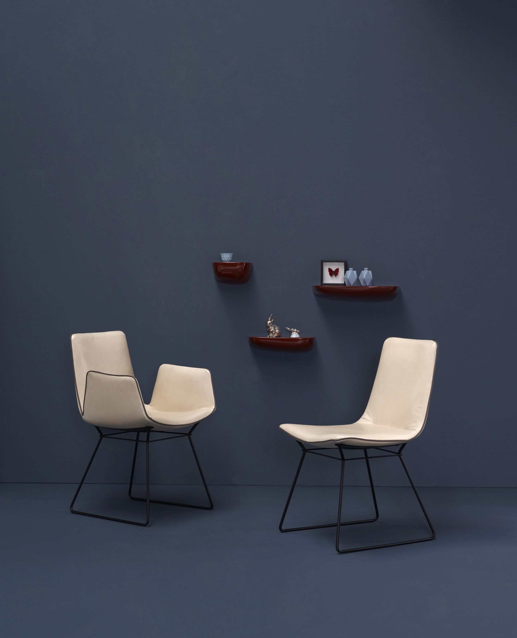 Zwei Amelie Armlehnstühle von Freifrau Manufaktur in Beige mit hohen Armlehnen und schwarzem Gestell.