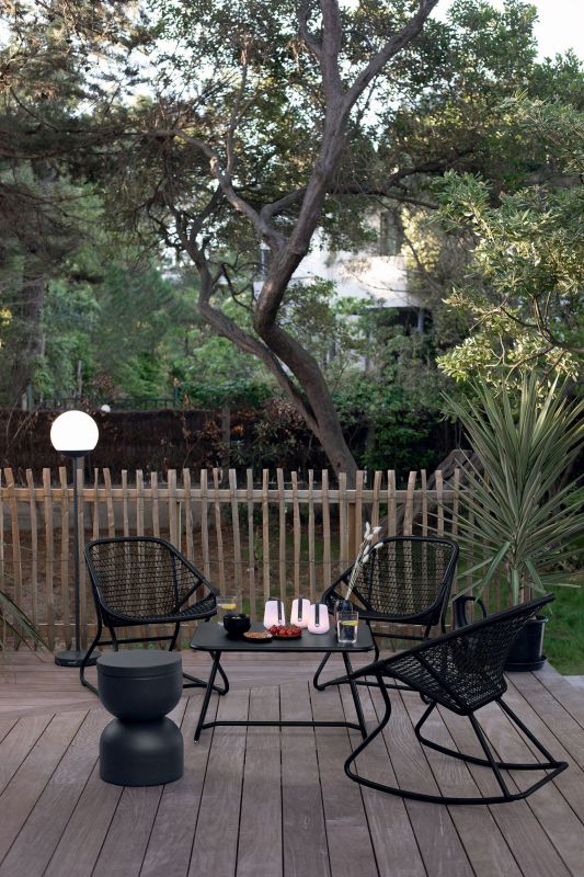 Gartenmöbel-Set mit Sixties Outdoor Sessel von Fermob, Tisch und Hocker in Schwarz auf Holzterrasse.