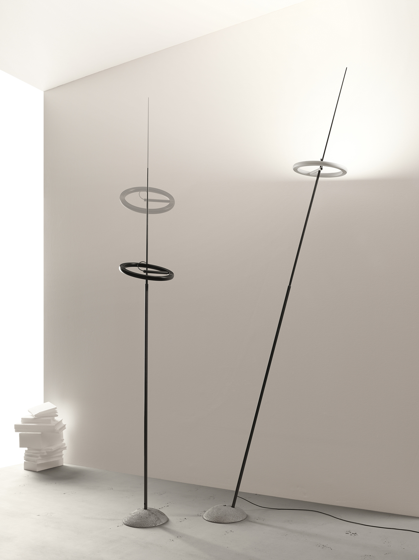 Zwei Ringelpiez Stehlampen von Ingo Maurer in Schwarz mit ringförmigem Leuchtkörper und Steinfuß.