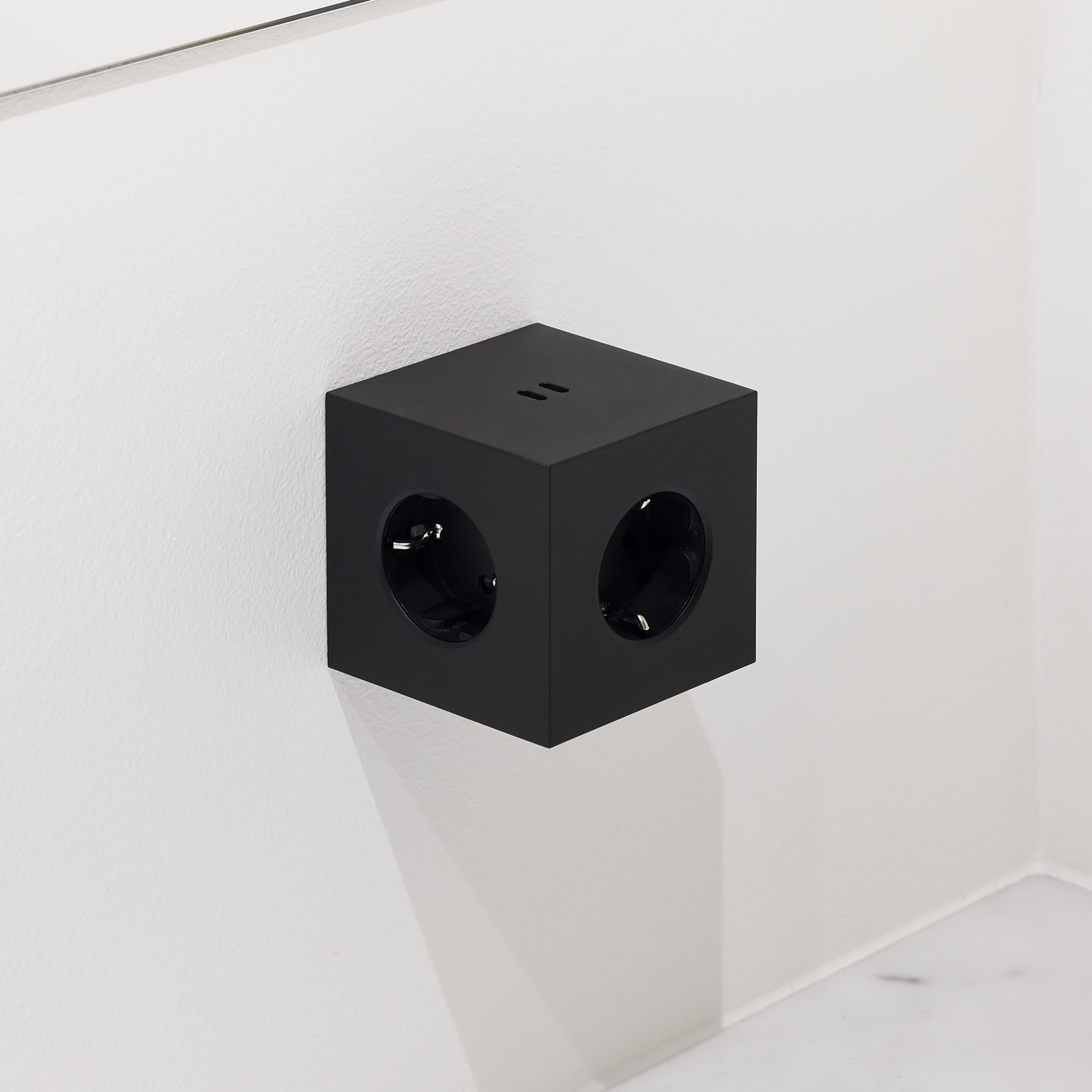 Schwarzer Avolt Square 2 Steckdosenwürfel mit USB-C an einer weißen Wand. Design Steckdose.