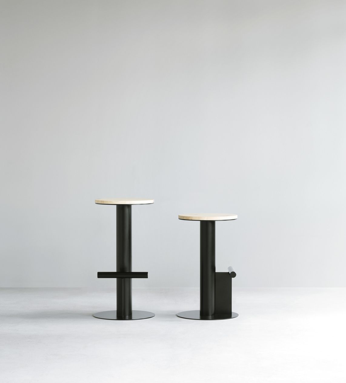 Zwei Pole Barstühle von Normann Copenhagen mit schwarzem Gestell und hellem Holz-Sitz.