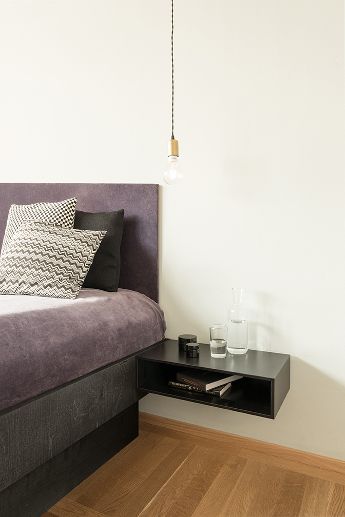 Schwarze Schönbuch Epoca Schubkastenkonsole als Nachttisch an der Wand montiert, mit Ablagefläche im Schlafzimmer.