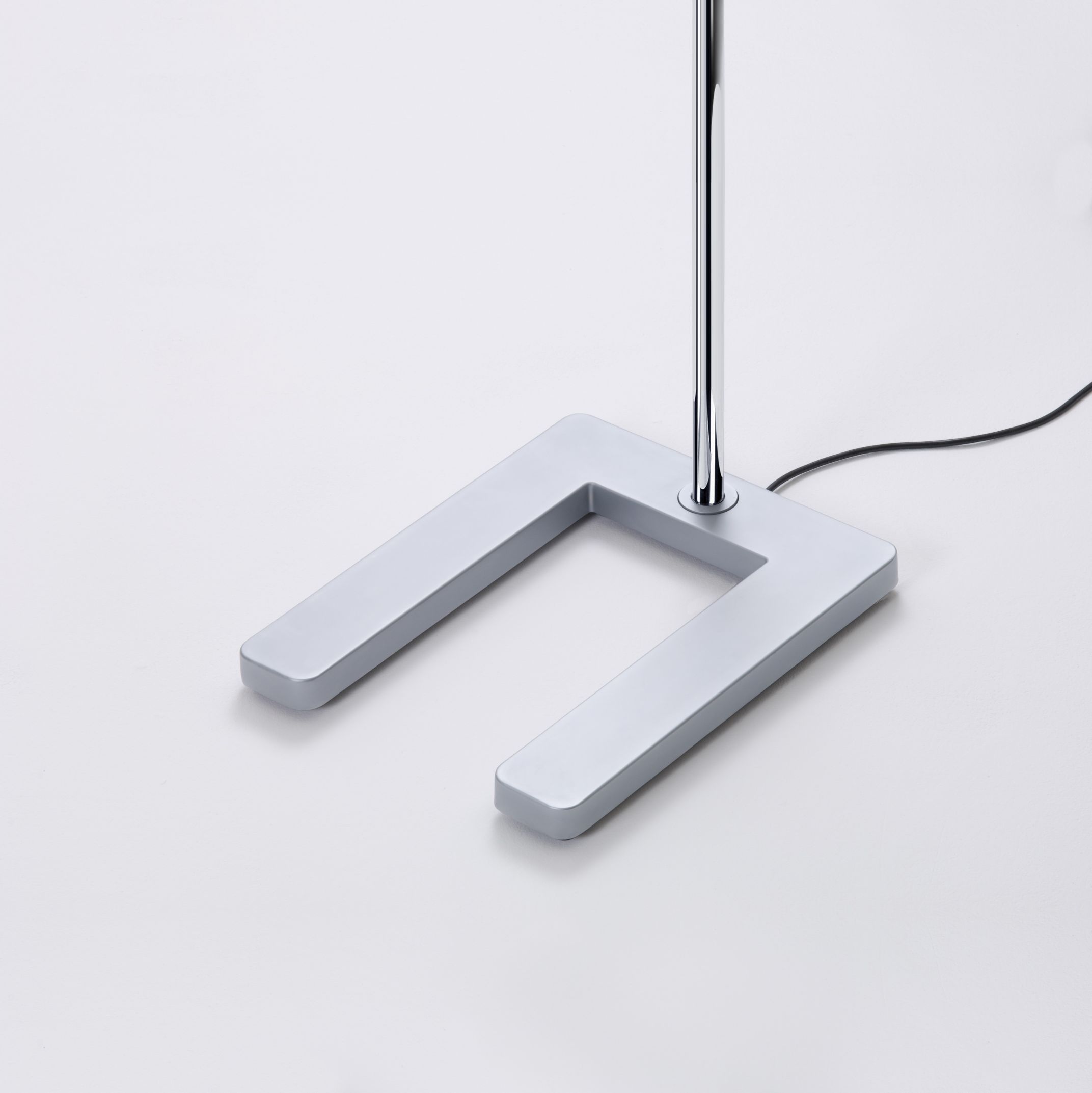 Detailaufnahme: Slice² Stehleuchte, glanzverchromt, mit Sensorik, Fokus auf U-förmigen Fuß.