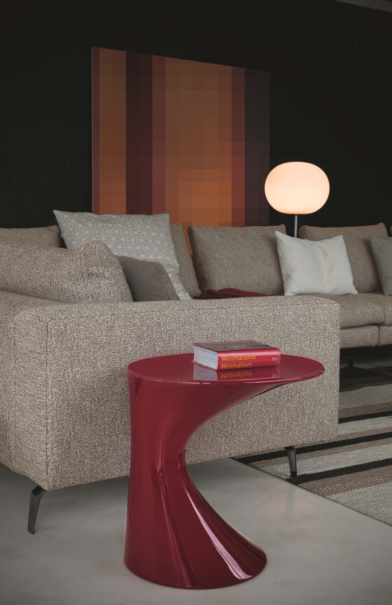Roter Tod Couchtisch von Zanotta neben einem beigen Sofa mit Kissen und einem Buch.