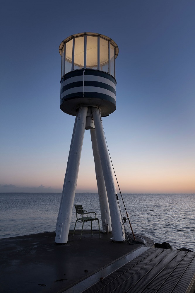 ReClips Stuhl am Meer: Grüner Outdoor Dining Chair von Houe vor Leuchtturm.