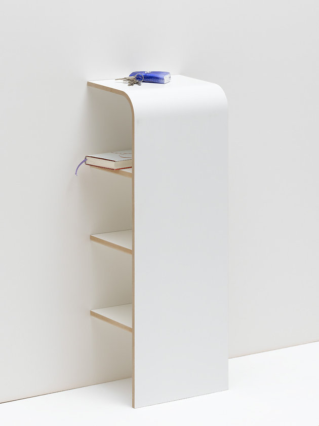 Weißes Tojo Regal mit drei Fächern, Schlüssel und Buch als Dekoration, minimalistisches Design.